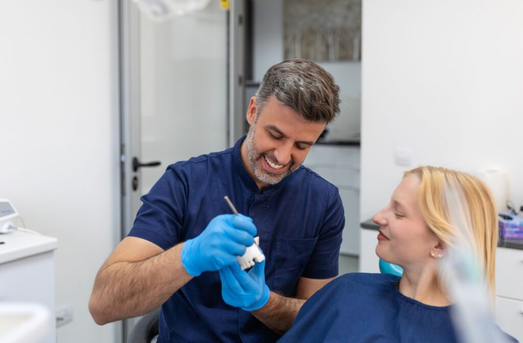 A dentist showing his patient how dental bridges can close the gaps in her teeth.