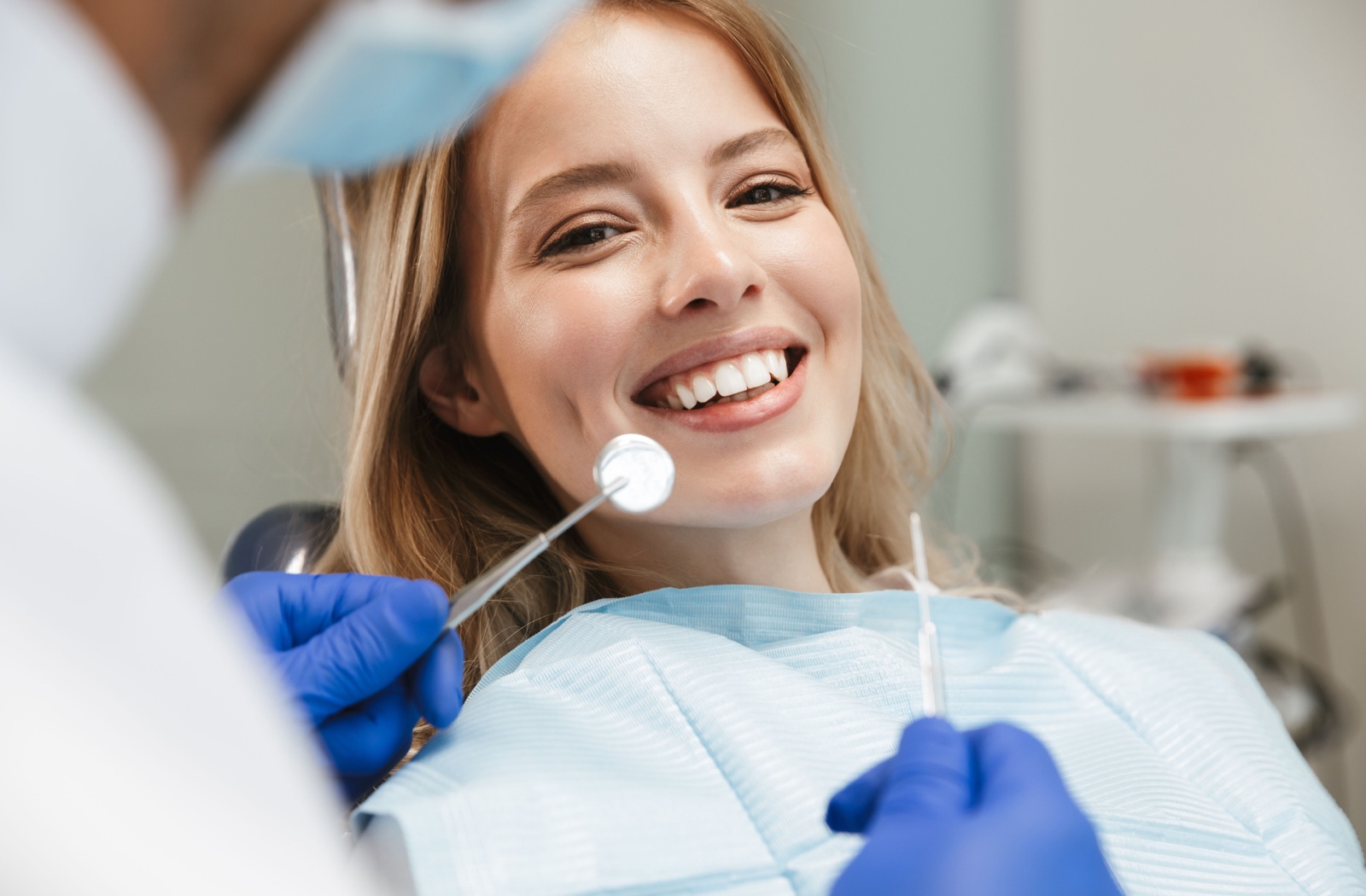 Patient smiling at annual dental check-up to catch early signs of enamel erosion.